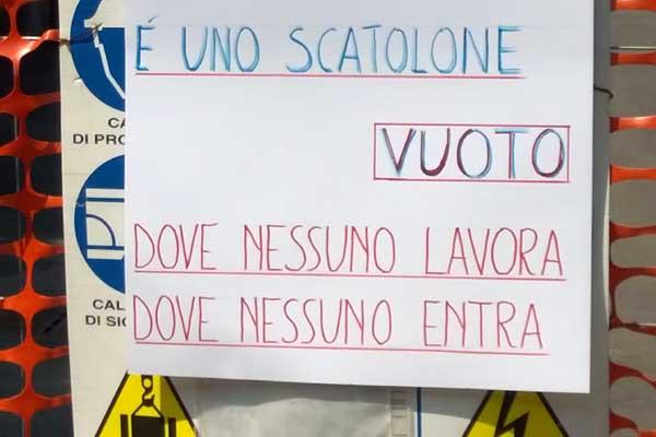 Cartello appare sulla recinzione del Pisu: “Allora è vero! E’ uno scatolone vuoto”