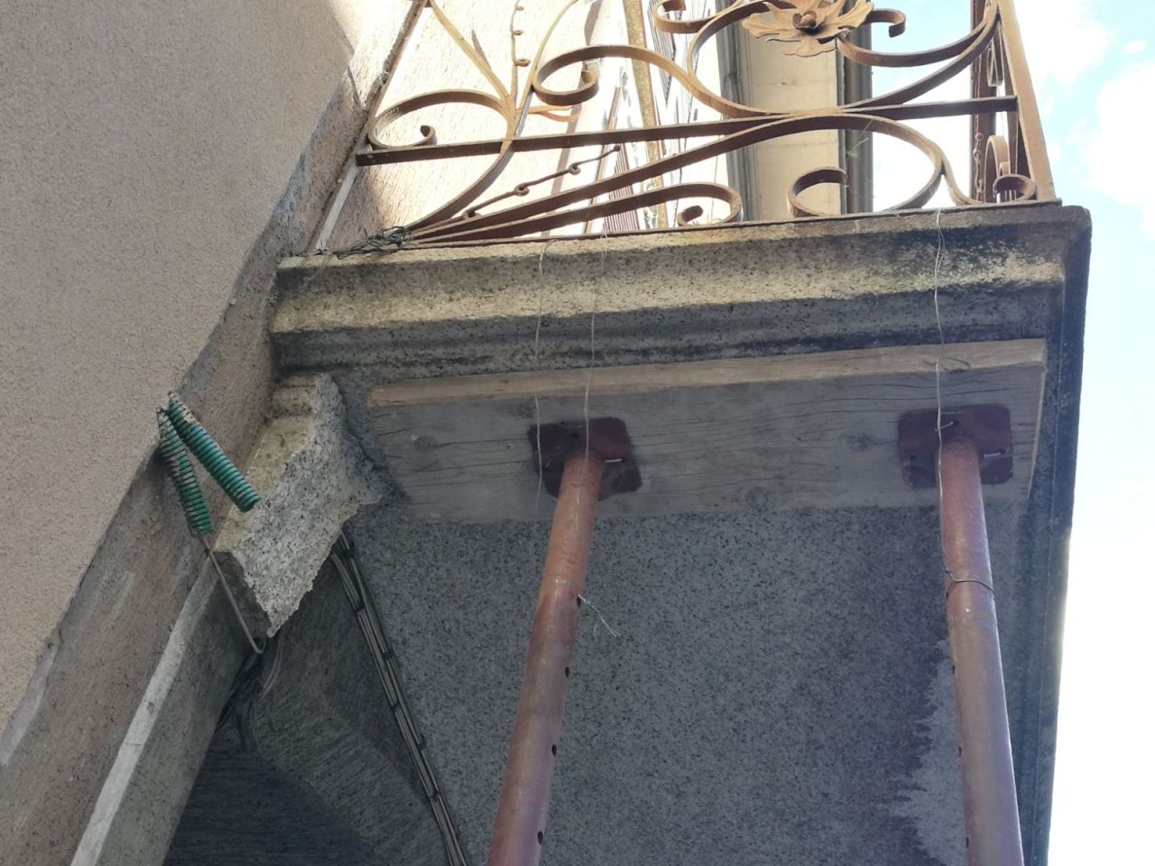 Camion incastrato in città distrugge il sostegno di un balcone