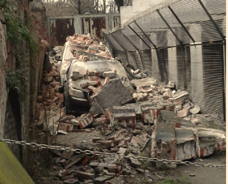 Crolla un muro durante i lavori, due auto distrutte