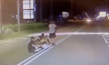 Ragazzini seduti di notte in mezzo alla Statale a Castelletto